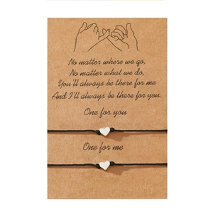 Lot de deux bracelets avec breloque cœur sur carte cadeau en papier kraft pour couples