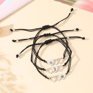 Macro detail of three woven bracelets with stainless steel sun moon and star heart charms