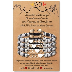 Détail de quatre bracelets d'amitié faits main avec cœurs et perles rayées noires et blanches