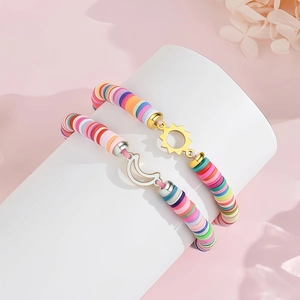 Detail of macaron clay heishi bead bracelets with gold sun and silver moon charms