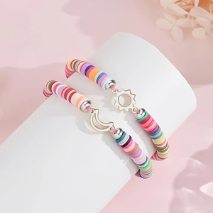 Detail of sun and moon friendship bracelets with colorful clay heishi beads and pink cord
