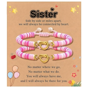 Roze en witte kleikralen armbanden met gouden hartknopen op een Sister-cadeaukaart