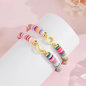 Detail of two colorful Heishi bead bracelets with sun and moon gold-tone charms