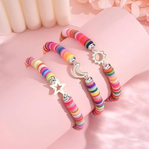 Detailed shot of rainbow heishi bead bracelets with silver sun moon and star charms