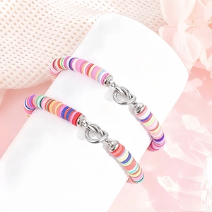 Detail van kleurrijke bohemien Heishi-kralenarmbanden met zilveren knoopsluiting