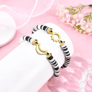 Close-up of sun and moon friendship bracelets with black and white clay beads