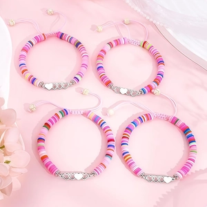 Détail de bracelets en perles d'argile colorées avec breloques cœur et cordons ajustables