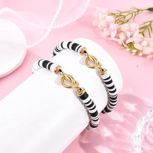 Detail van kralenarmbanden met hartknoop en zwart-witte polymeerklei schijfjes