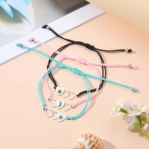 Detailed shot of three woven couple bracelets with sun moon star heart charms