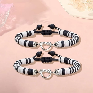 Detail van de hartvormige knoopsluiting op de zwart-witte kralenarmbanden van klei