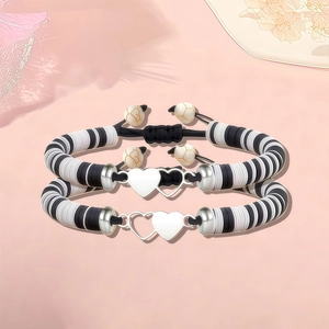 Gros plan sur des bracelets en perles de polymère avec breloques en forme de cœur entrelacés