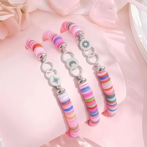 Gros plan de trois bracelets de perles faits main avec breloques soleil, lune et étoile