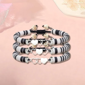 Lot de trois bracelets en perles d'argile noir et blanc avec cœurs argentés entrelacés