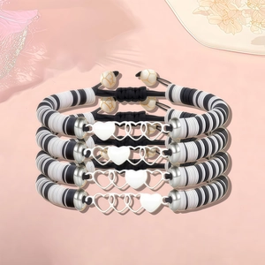 Détail de bracelets tressés réglables avec breloques en cœur et perles bicolores
