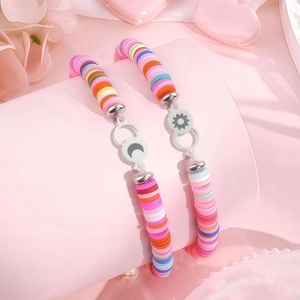 Détail de bracelets en perles Heishi colorées avec pendentifs soleil et lune rose