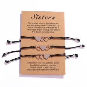 Détail de trois bracelets de sœur en forme de cœur sur une carte de vœux cadeau