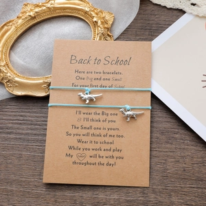 Detail von hellblauen Dinosaurier Armbändern auf Karte als Geschenk zum Schulanfang