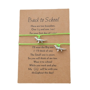 Detail von grünen Dinosaurier-Armbändern auf Geschenkarten zum Schulanfang für Kinder