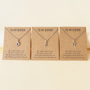 Ensemble de trois colliers en acier avec soleil, lune et étoile sur carte cadeau