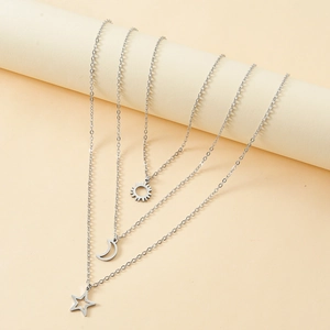 Détail des colliers avec pendentifs soleil lune et étoile sur un support élégant