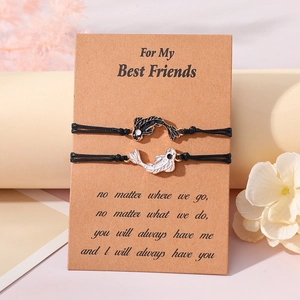 Detail of woven Yin Yang koi fish bracelets on a kraft card with dried floral background