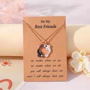 Close-up of Yin Yang fish friendship necklaces on brown kraft card with floral background