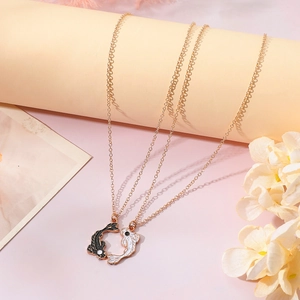 Detail of Yin Yang fish couple necklaces with gold chains and black white enamel charms