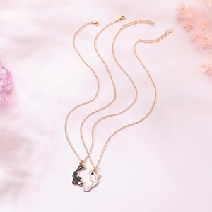 Detailed macro view of black and white koi fish necklaces with gold alloy link chains