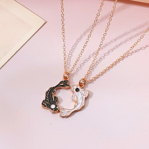 Close-up of rose gold koi fish yin yang pendant necklaces for friends on pink background