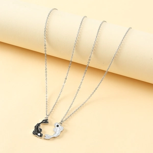 Detail of Yin Yang fish pendant necklaces with intricate enamel work on silver link chain