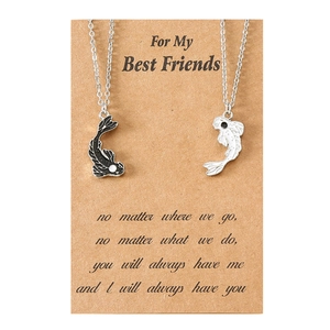 Detailed view of black and white yin yang fish friendship necklaces on kraft gift card