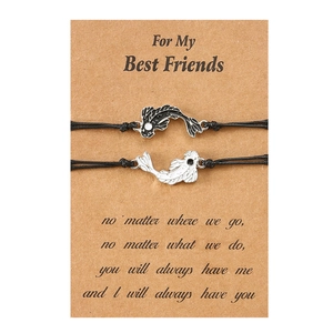Close-up of magnetic yin-yang fish friendship bracelets on brown gift card packaging