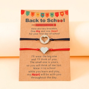 Detail of red and black woven back to school bracelets with steel heart charms