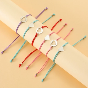 Detail of colorful woven mother-daughter bracelets with heart pendants on a display stand