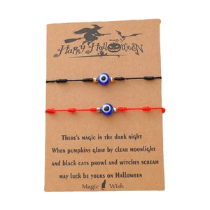 Détail de bracelets mauvais œil rouges et noirs sur une carte cadeau Halloween