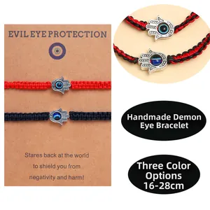 Détail de bracelets tressés rouge et noir avec breloques Main de Fatma et Mauvais Œil