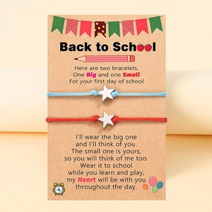 Nahaufnahme von Sternarmbändern auf Schulanfang-Karte mit Gedicht für den ersten Schultag