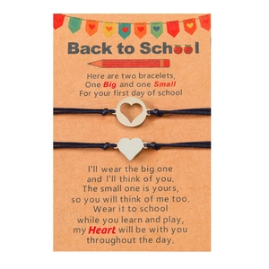 Detail of woven back to school bracelets with silver heart charms on a message card