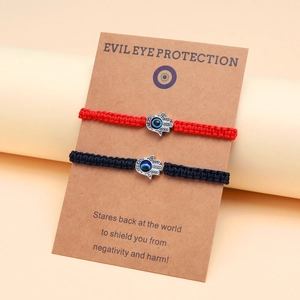 Détail des bracelets mauvais œil rouges et noirs sur carte d'emballage en papier kraft