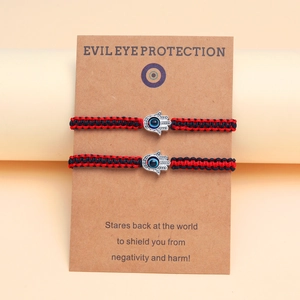 Détail de bracelets Hamsa œil protecteur tressés sur une carte de présentation Kraft