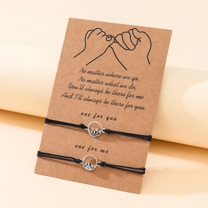 Detail von Berg- und Wellenanhängern an handgewebten Paararmbändern mit Geschenkkarte