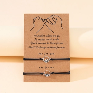 Nahaufnahme gewebter Berg- und Wellenarmbänder auf Karte mit Pinky-Promise-Symbol