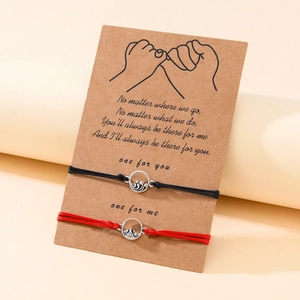 Detailansicht der gewebten Berg- und Meer-Pärchenarmbänder auf einer Kraftpapierkarte