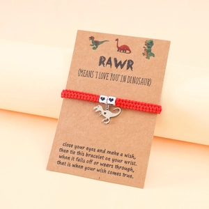 Detail of red braided dinosaur charm bracelet with heart beads on gift card