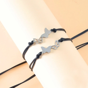 Detail of hand-woven black cord bracelets with hollow and solid butterfly charms