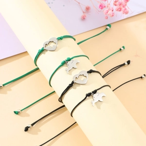 Detailed macro view of handmade braided rope bracelets with heart and dolphin charms