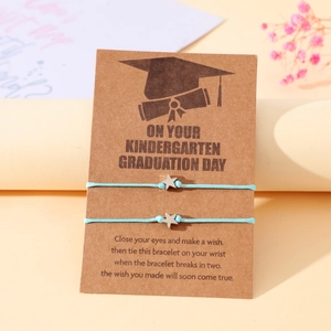 Dettaglio di braccialetti intrecciati con stella su biglietto d'auguri per diploma