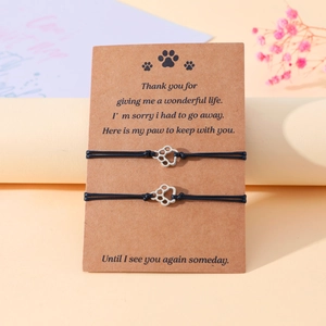 Detail of woven pet paw memorial bracelets on display card with comfort message