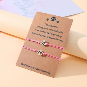 Detailed view of pink woven pet memorial bracelets with alloy paw charm on card