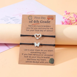 Details von zwei gewebten Armbändern mit Schmetterlingsanhängern auf Geschenkkarte
